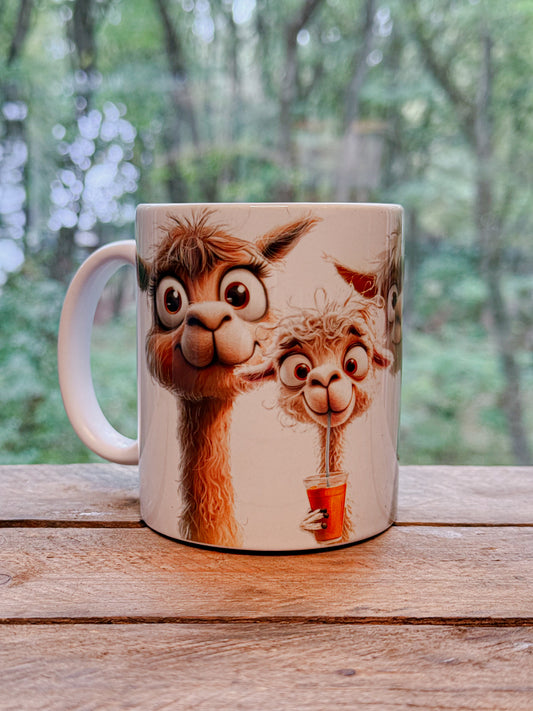 Weiße Tasse mit einem braunen erwachsenen Alpaka und einem weißen Alpaka-Kind mit einem roten Getränke mit Strohhalm in der Hand